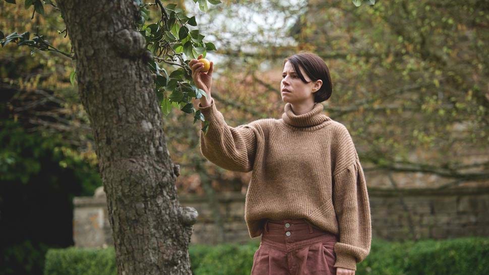 Girl holding an apple near a tree